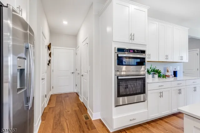 a kitchen with stainless steel appliances granite countertop a stove and white cabinets