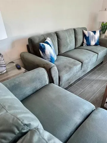 a kitchen with stainless steel appliances a microwave a stove a sink dishwasher a refrigerator and white cabinets with wooden floor