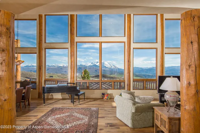 a living room filled with furniture and a floor to ceiling window