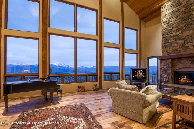 a living room with fireplace furniture and a floor to ceiling window