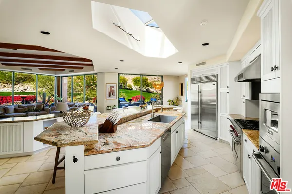 a kitchen with stainless steel appliances granite countertop a sink and a refrigerator