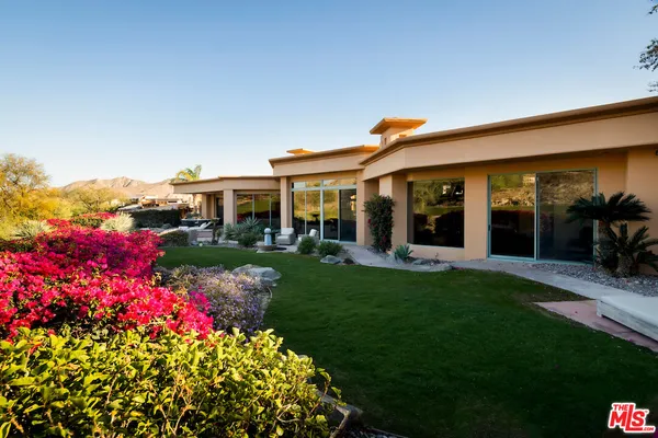 a front view of a house with a big yard and fountain