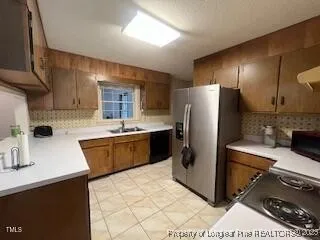 a kitchen with stainless steel appliances a stove a sink a refrigerator and cabinets