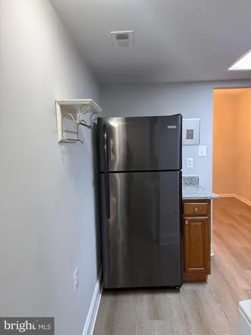 a kitchen with granite countertop wooden cabinets and a refrigerator