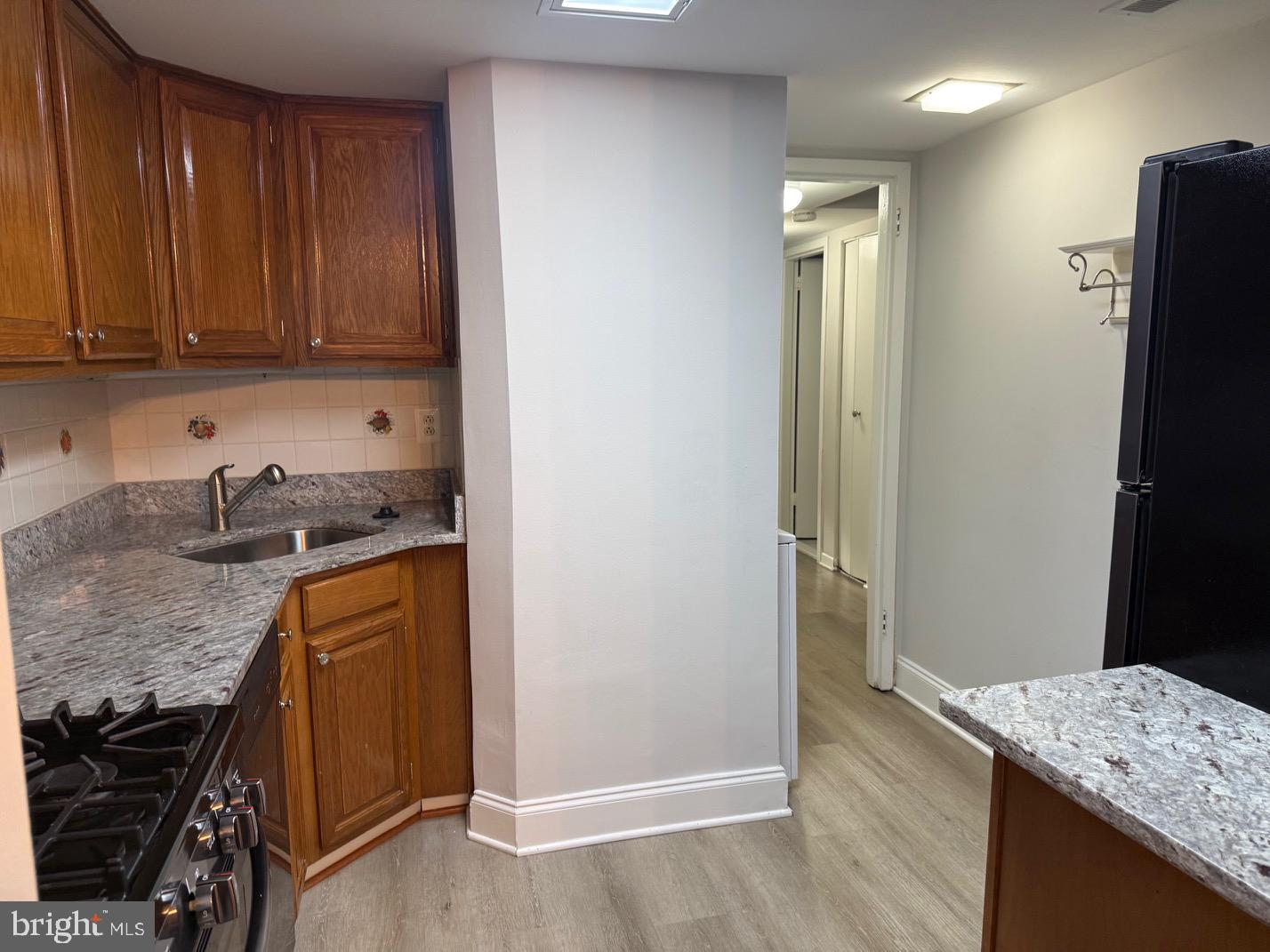 1400 Northgate Square, Unit 11A Reston, VA 20190 - Photo 5 of 21 a kitchen with granite countertop wooden cabinets and a refrigerator
