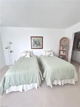 a spacious bedroom with a bed and painting on the wall