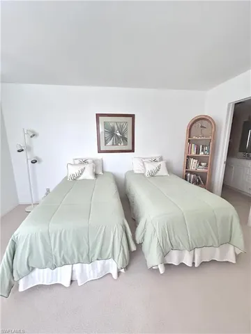 a spacious bedroom with a bed and painting on the wall