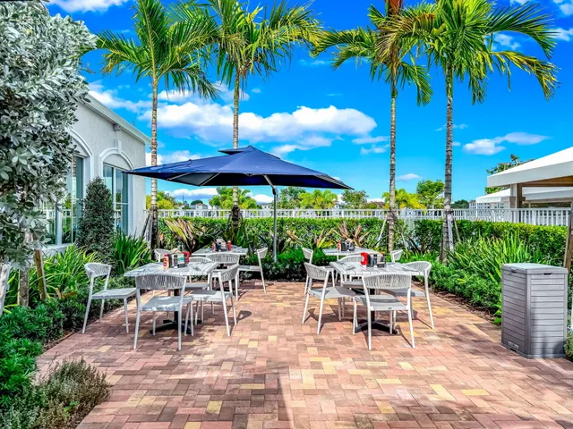 a view of a patio with a table and chairs under an umbrella