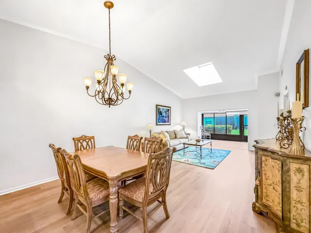 a view of a dining room with furniture a chandelier and wooden floor