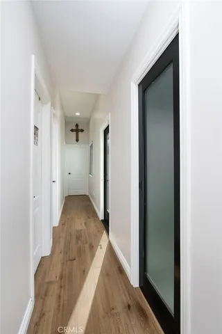 a view of a hallway with wooden floor and staircase