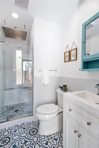 a bathroom with a sink a toilet and shower