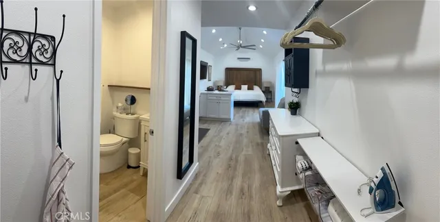 a walk in closet with wooden floor and a bathroom view