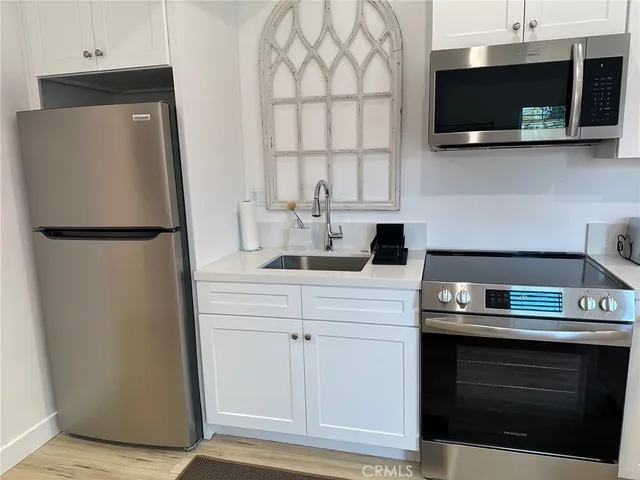 a kitchen with stainless steel appliances a refrigerator sink and microwave