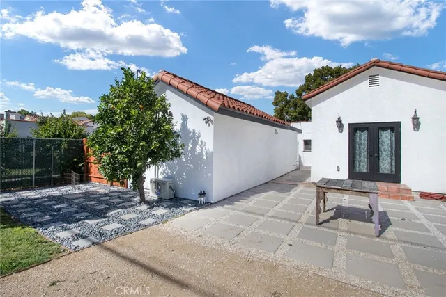 a backyard of a house with table and chairs