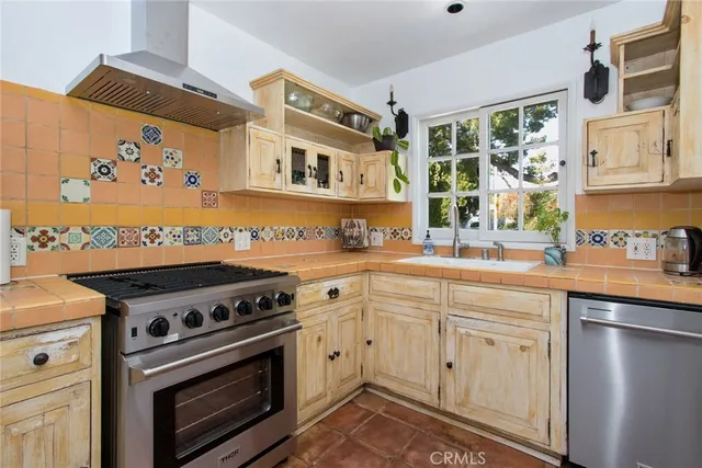 a kitchen with stainless steel appliances a stove a sink and a microwave