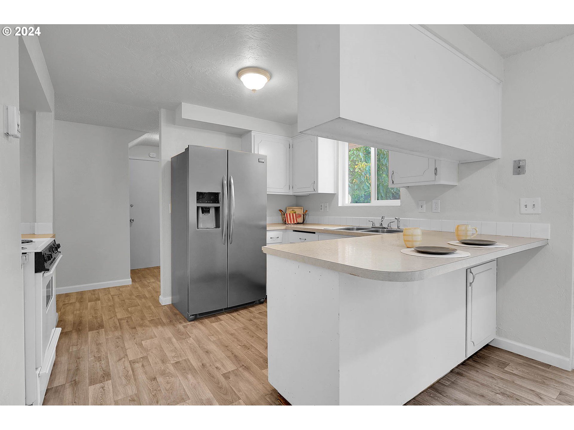 4250 Scenic Drive Eugene, OR 97404 - Photo 23 of 31 a kitchen with stainless steel appliances granite countertop a sink a refrigerator and wooden floor