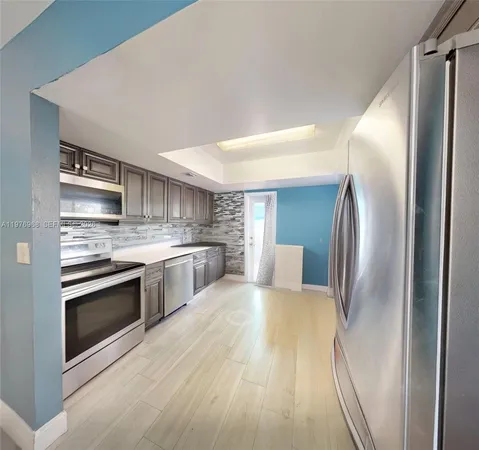 a kitchen with stainless steel appliances granite countertop a refrigerator and a stove top oven
