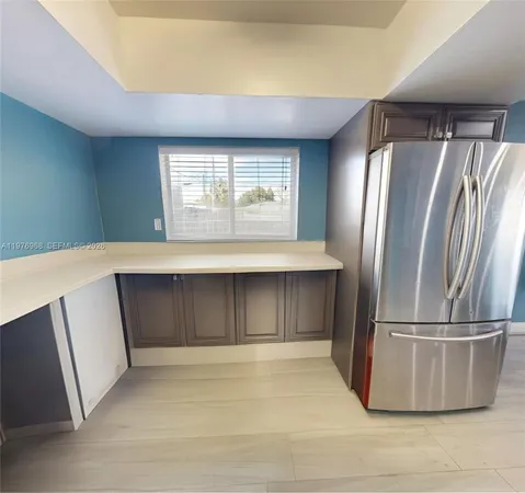 a view of empty room with a kitchen and a window
