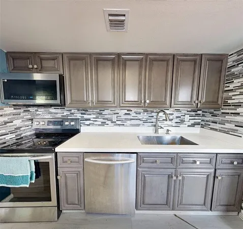 a kitchen with white cabinets and sink