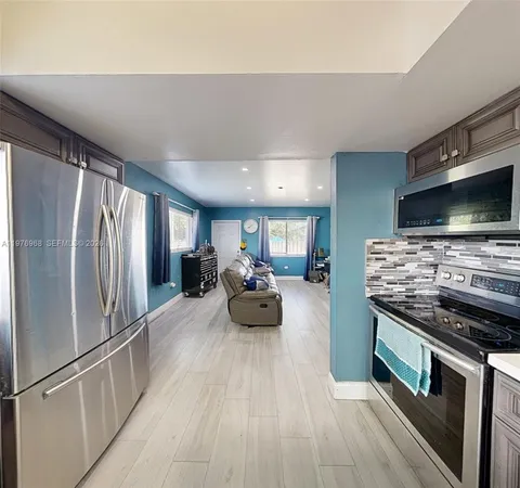 a kitchen with microwave a stove and cabinets