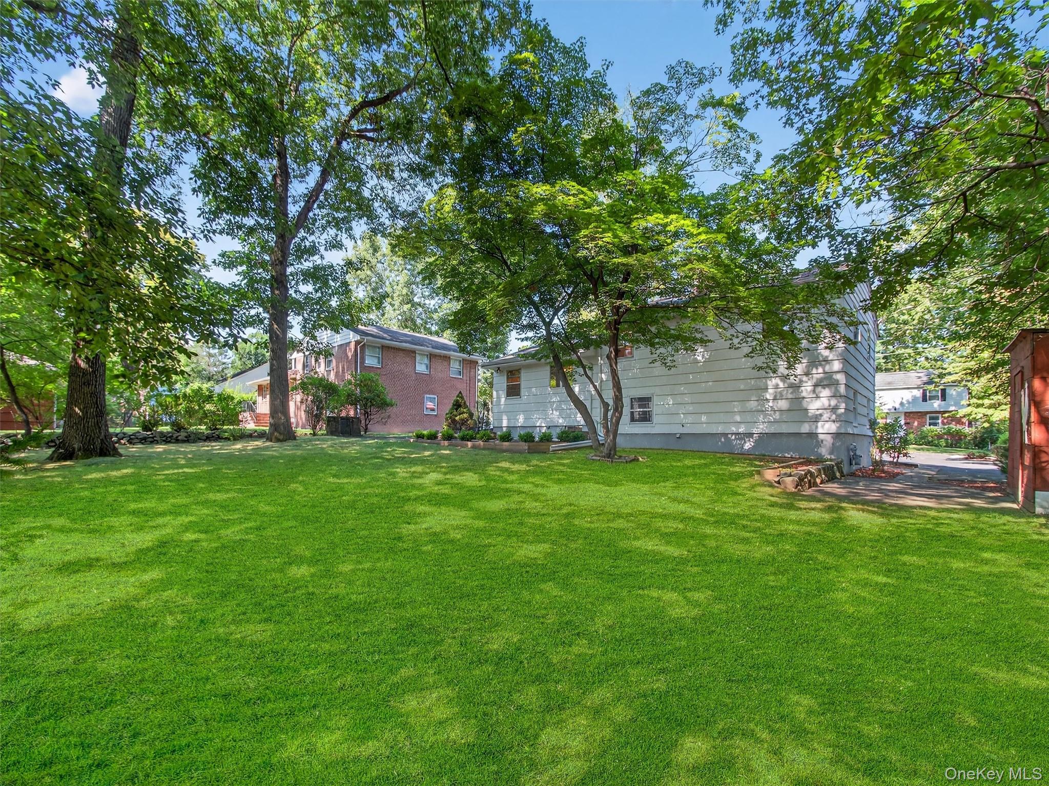 2 Beech Road Suffern, NY 10901 - Photo 24 of 24 a view of a backyard with table and chairs and a large tree