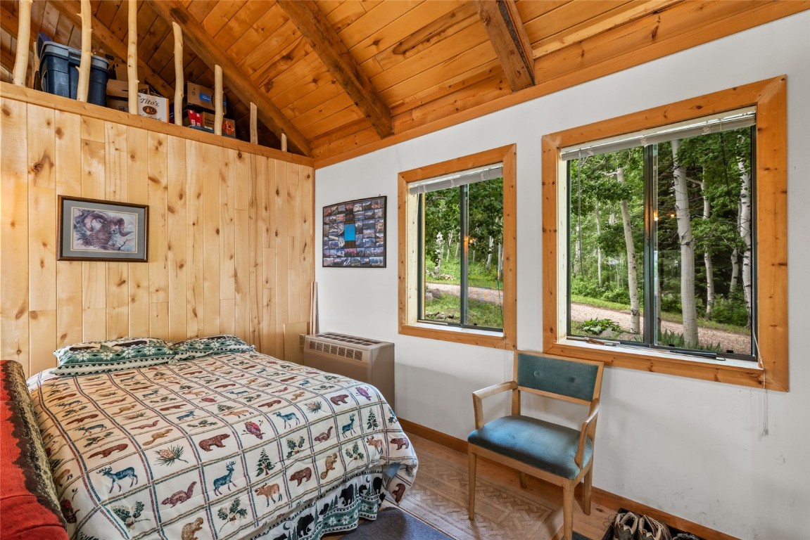 389 Routt Forest Loop Craig, CO 81625 - Photo 15 of 49 a bedroom with a bed and wooden floor