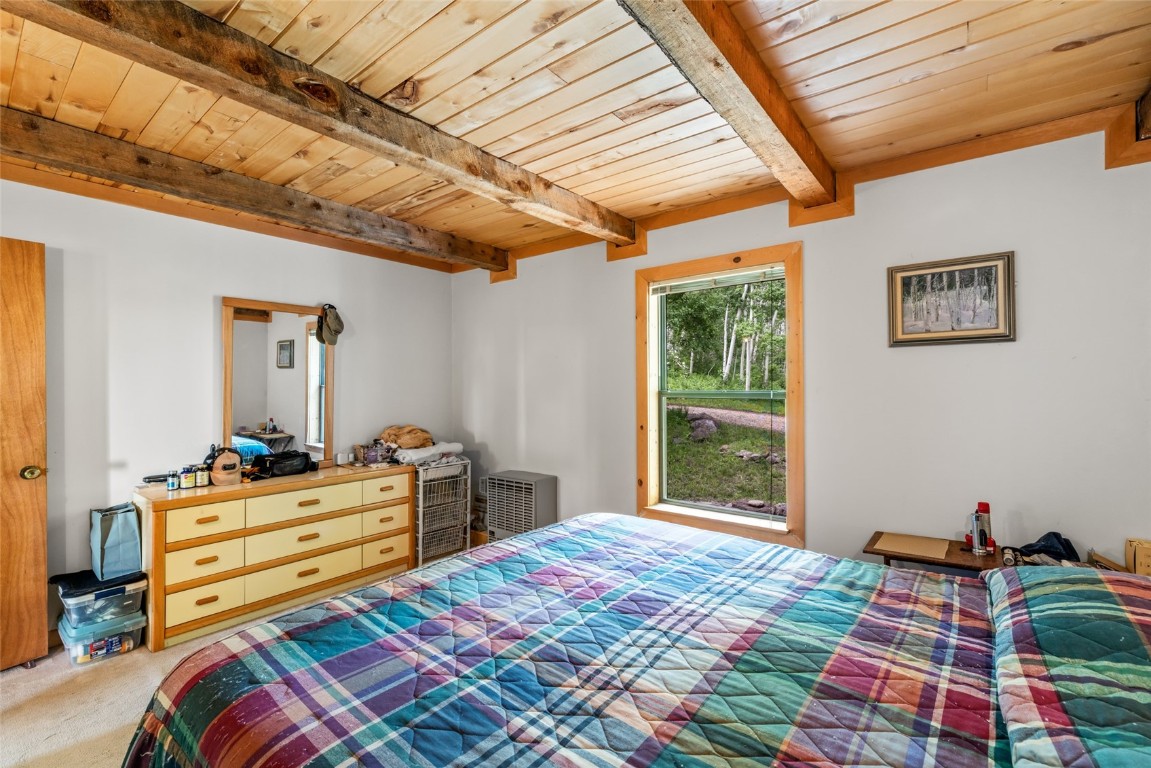 389 Routt Forest Loop Craig, CO 81625 - Photo 22 of 49 a bedroom with a bed next to a window