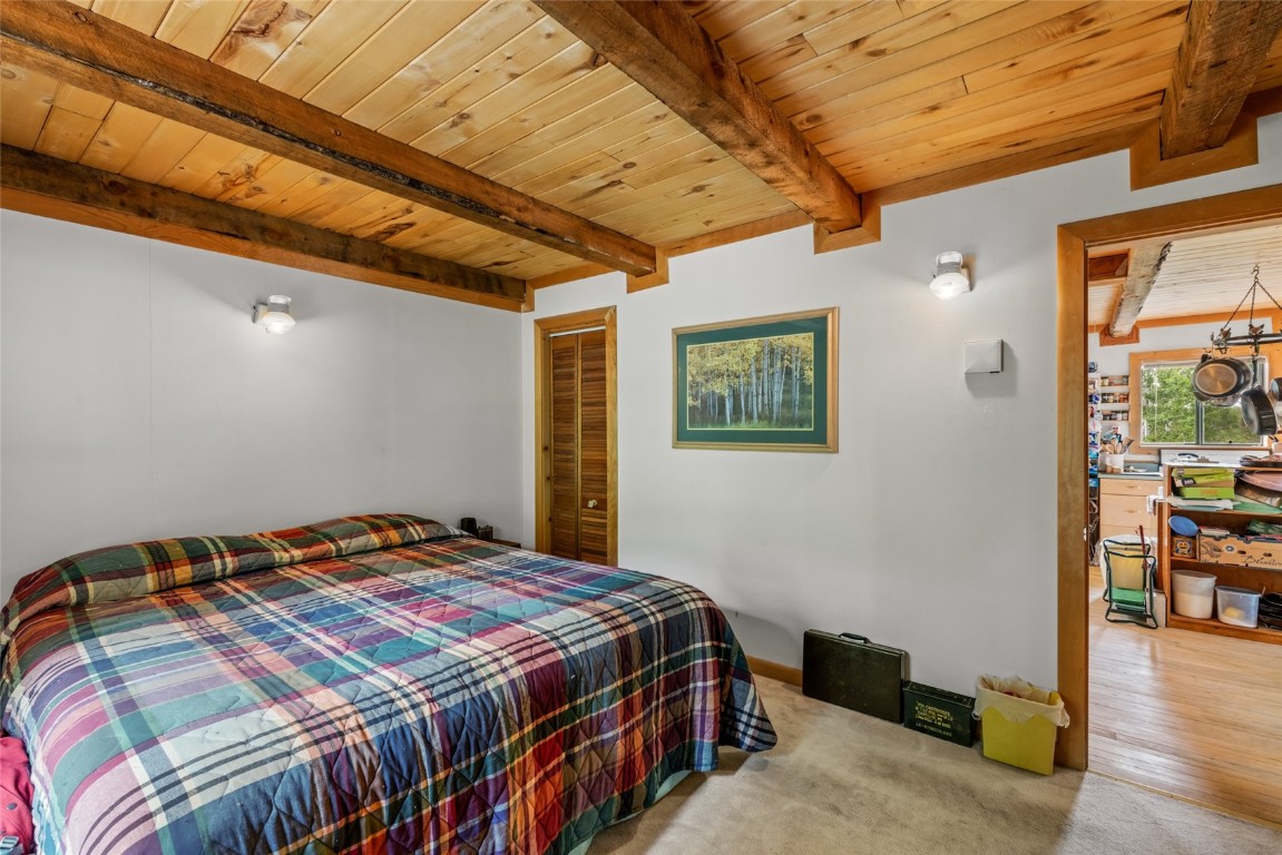 389 Routt Forest Loop Craig, CO 81625 - Photo 23 of 49 a bedroom with a bed and wooden floor