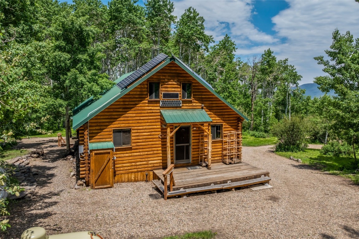 389 Routt Forest Loop Craig, CO 81625 - Photo 37 of 49 a backyard of a house with barbeque oven and trees