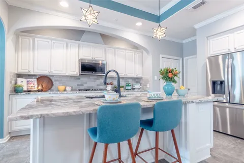 a kitchen with stainless steel appliances granite countertop a sink refrigerator and microwave