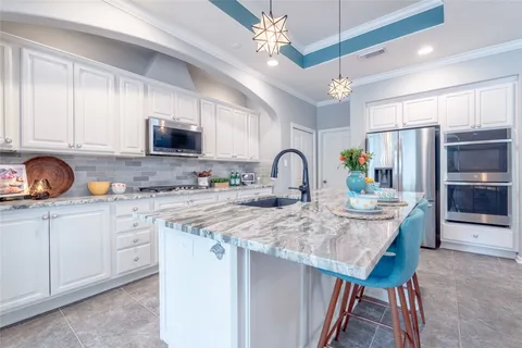 a kitchen with stainless steel appliances granite countertop a sink a stove and a refrigerator