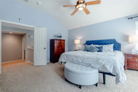 a spacious bedroom with a bed a couch and a flat tv screen