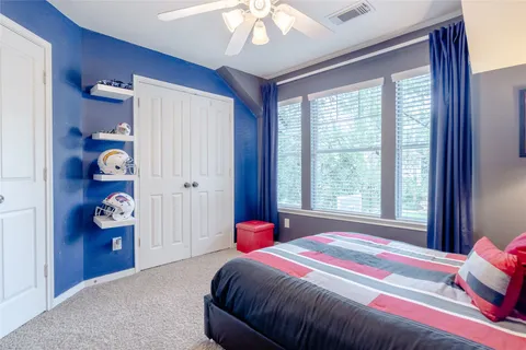 a spacious bedroom with a bed and a chandelier