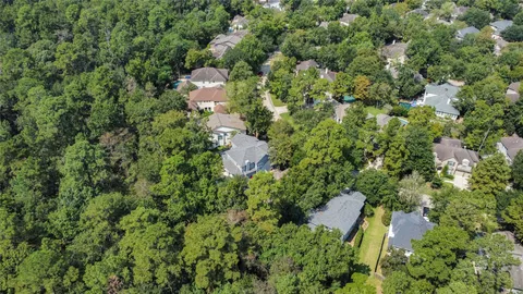 an aerial view of residential house with outdoor space and trees all around