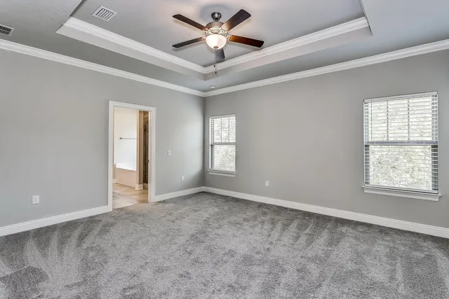 a bedroom with a large bed chandelier and a window