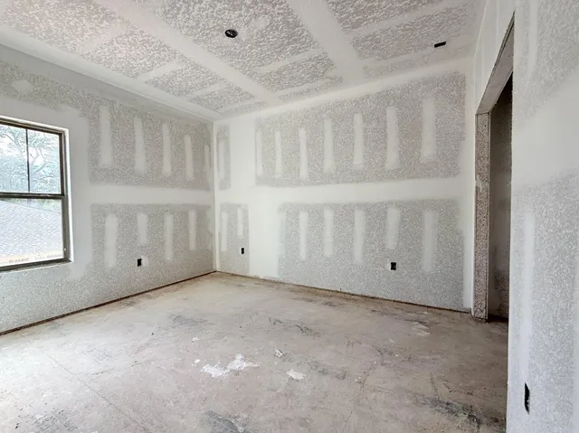 an empty room with a window and a fan