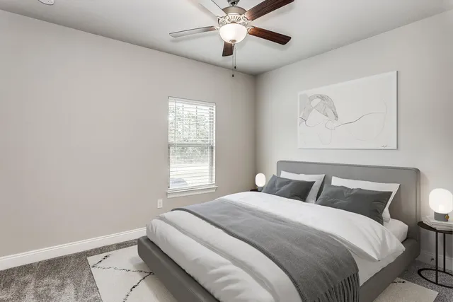 a bathroom with a granite countertop bathtub shower sink vanity mirror and toilet