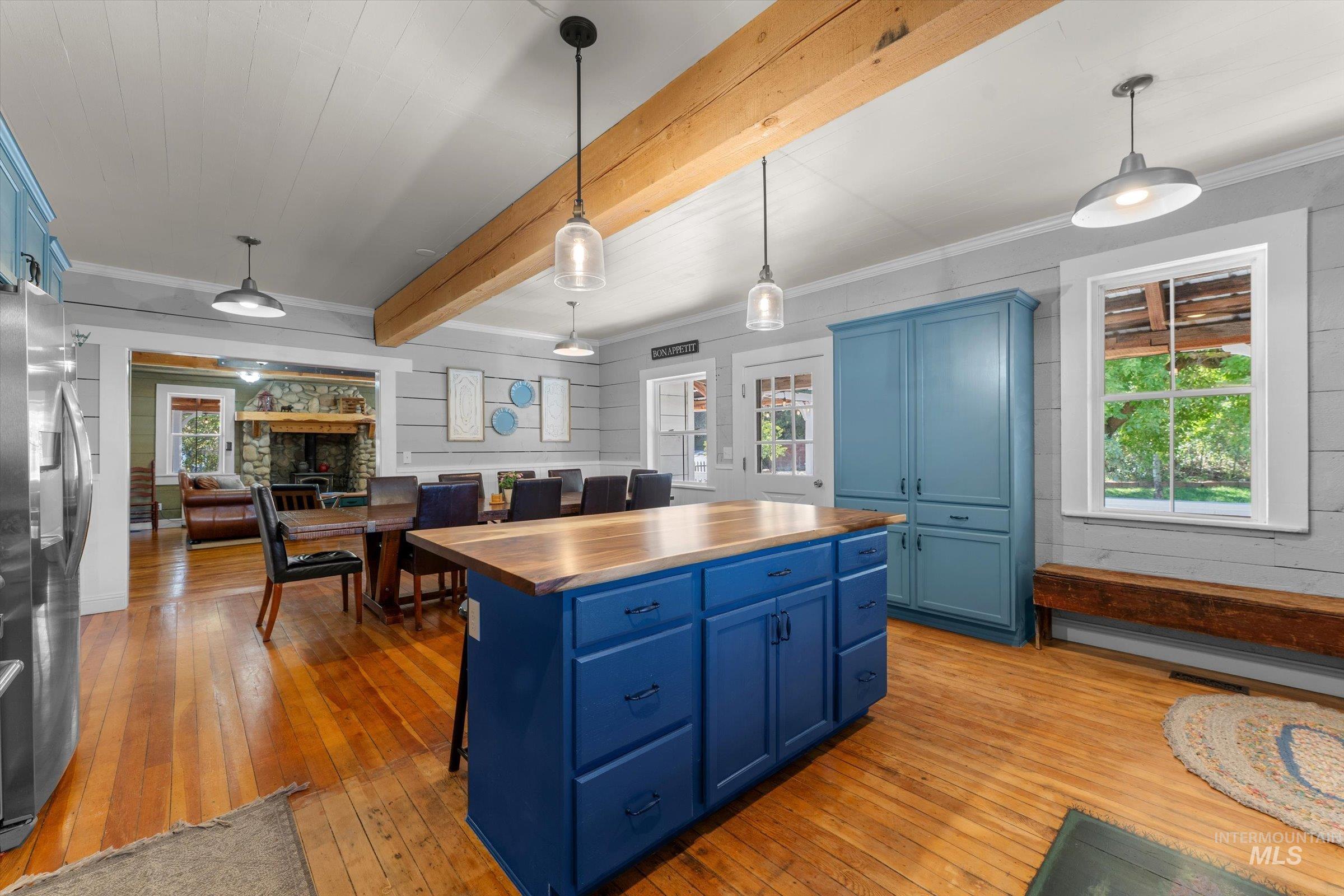 315 South Middlefork Road Garden Valley, ID 83622 - Photo 14 of 49 Kitchen with blue cabinetry, butcher block countertops, decorative light fixtures, light wood finished floors, and beamed ceiling