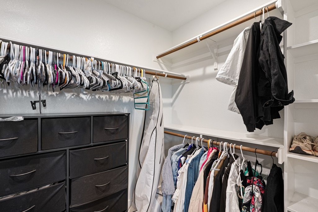 7403 Travertine Spring Drive, Unit 117 Austin, TX 78744 - Photo 24 of 37 Ample hanging space and storage solutions elevate this organized walk-in closet.