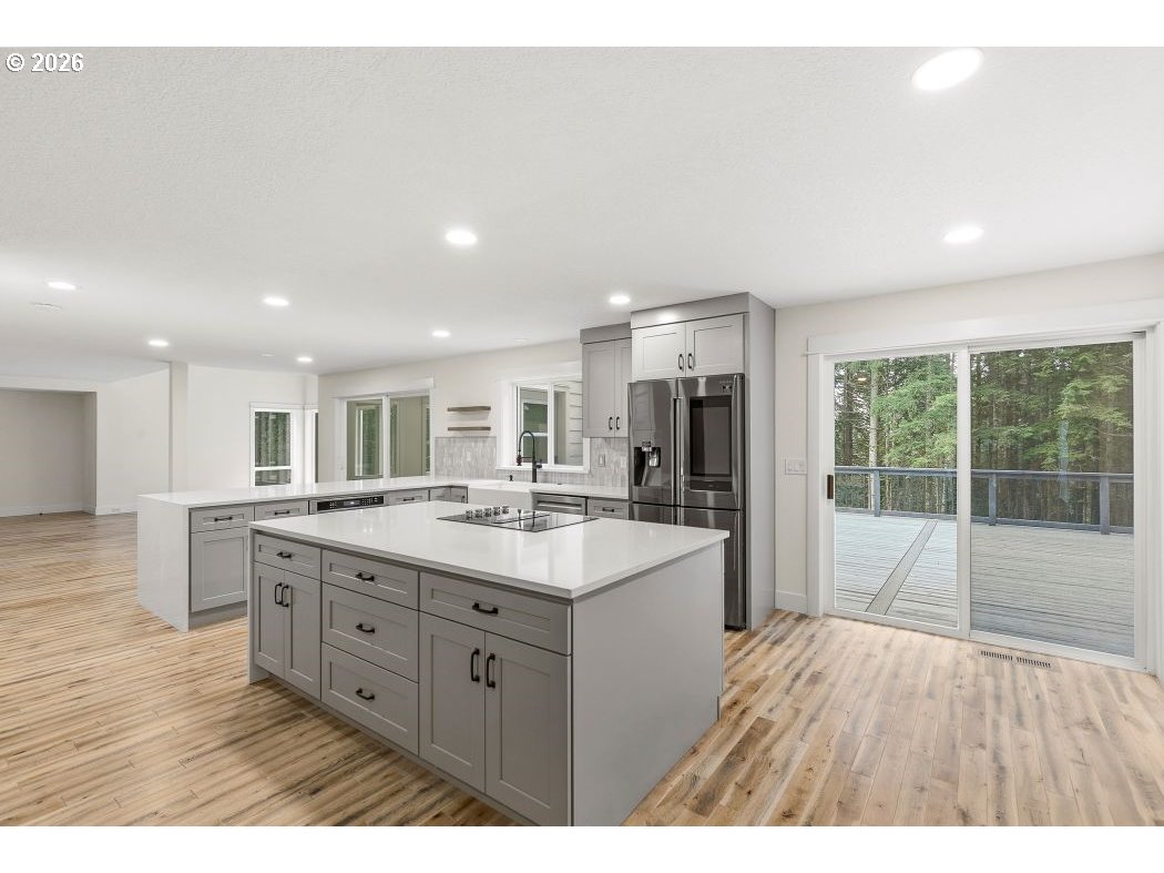 3708 Northeast 292nd Avenue Camas, WA 98607 - Photo 6 of 44 a large kitchen with kitchen island a sink dishwasher a stove and a refrigerator with wooden floor