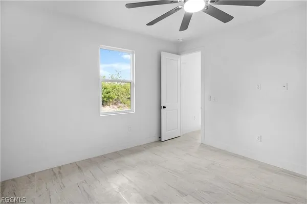 an empty room with fan and windows