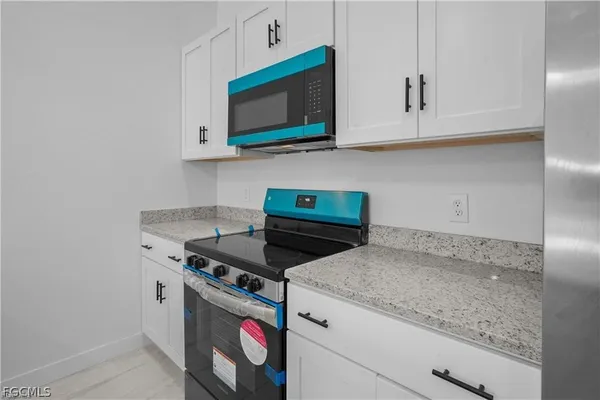 a kitchen with stainless steel appliances granite countertop a sink and a microwave