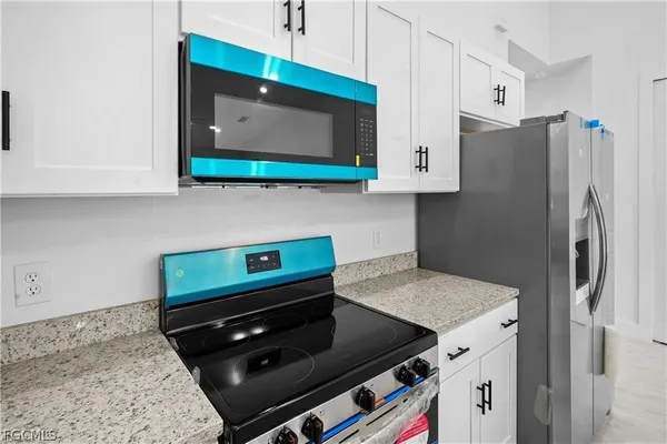 a kitchen with stainless steel appliances granite countertop a refrigerator and a stove