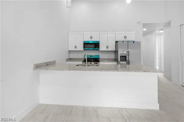 a kitchen with kitchen island a sink and a refrigerator