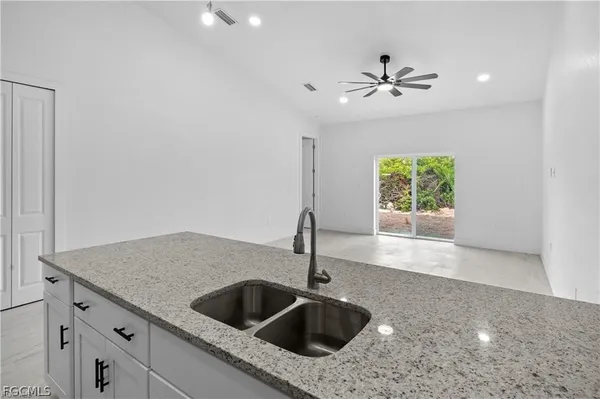 a view of kitchen with stainless steel appliances refrigerator oven and white cabinets