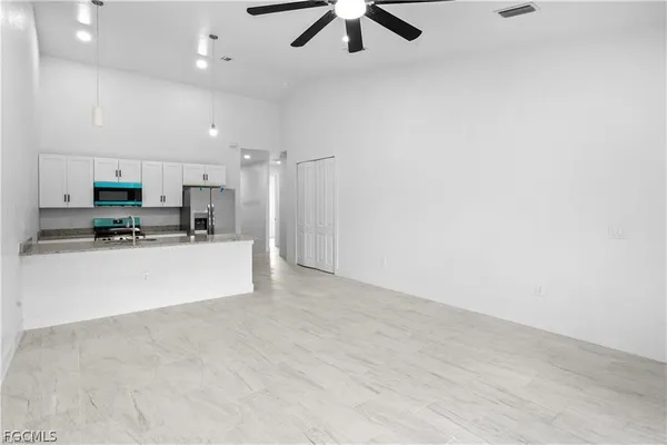 an empty room with fan and windows
