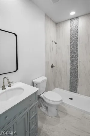 a bathroom with a sink a toilet and shower