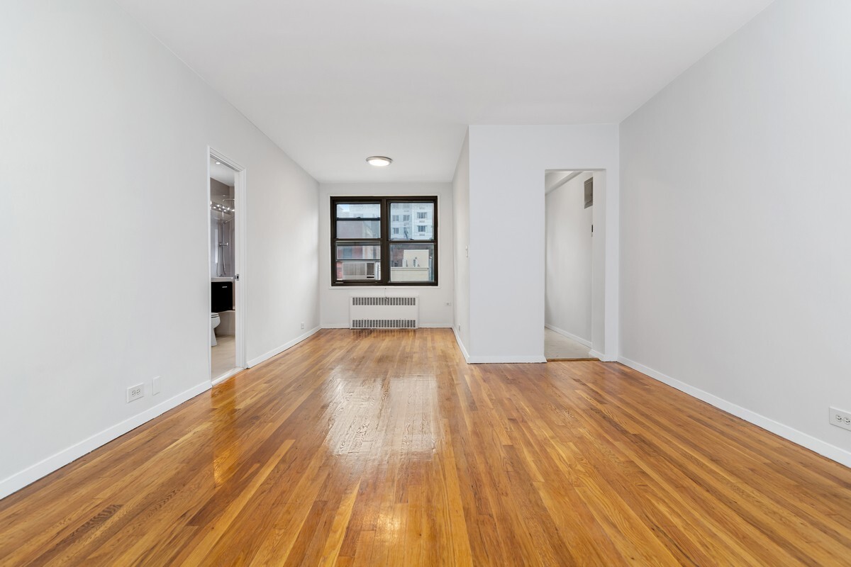 242 East 38th Street, Unit 5E Manhattan, NY 10016 - Photo 3 of 9 wooden floor in an empty room with a window