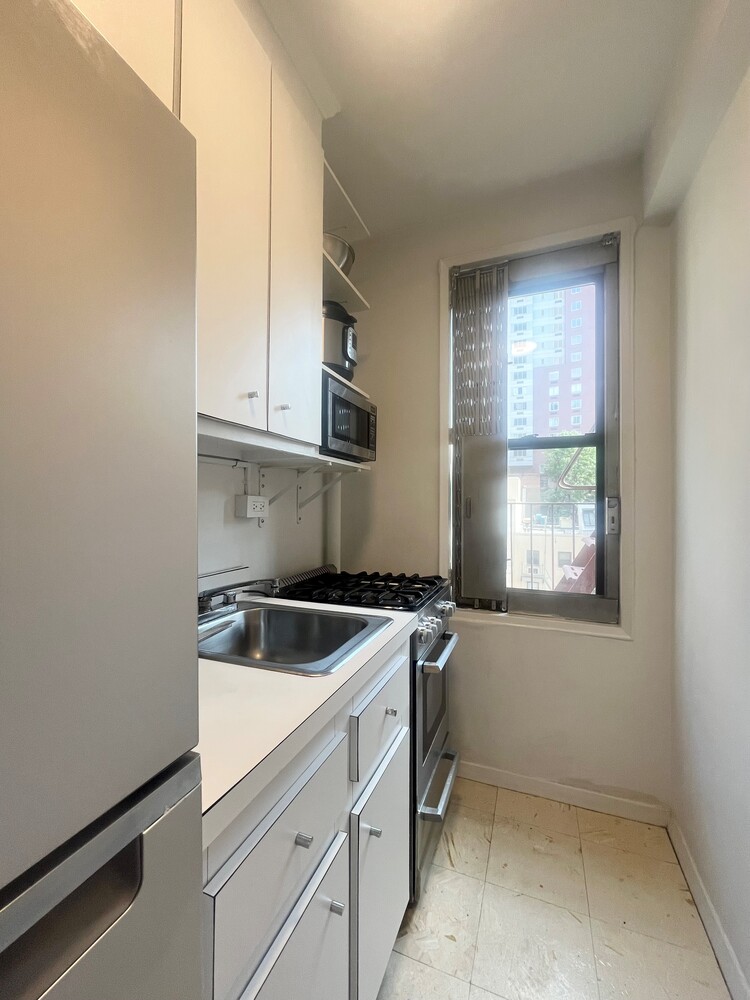 242 East 38th Street, Unit 5E Manhattan, NY 10016 - Photo 6 of 9 a kitchen with granite countertop a sink and a stove top oven