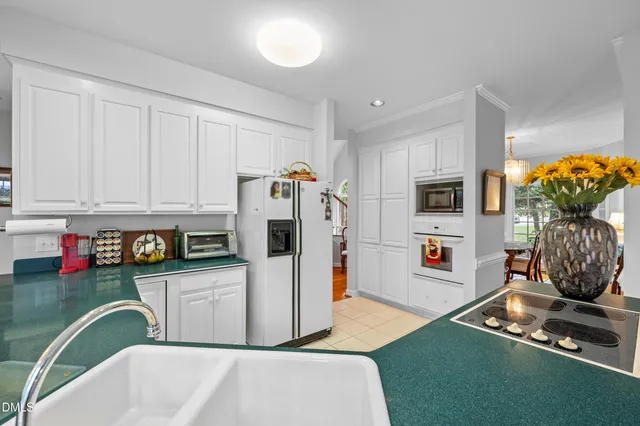 a kitchen with stainless steel appliances kitchen island granite countertop a refrigerator a stove and a sink